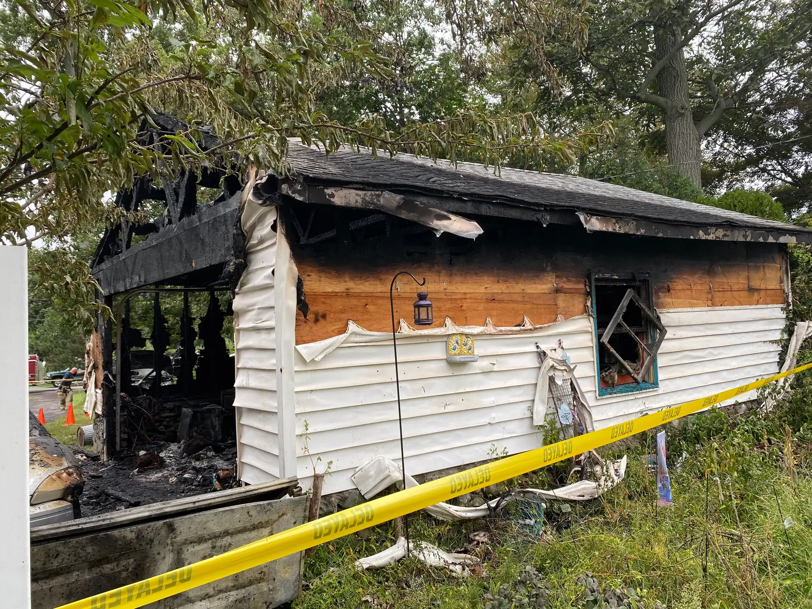 Fire-damaged garage with burned roof structure before demolition