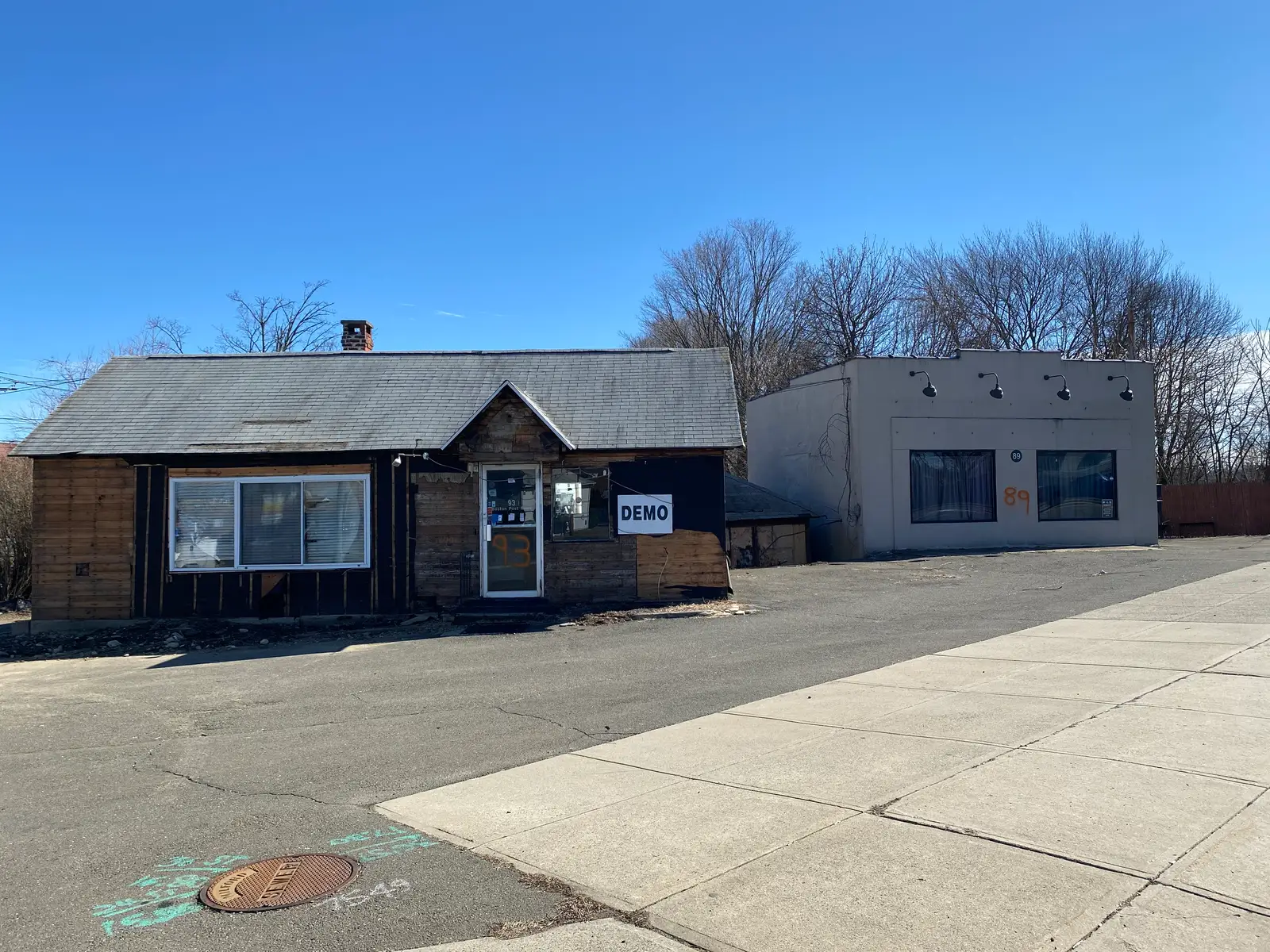Derelict building marked DEMO before demolition on the Post Road in Milford, CT
